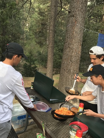 Group at a camp table in the woods